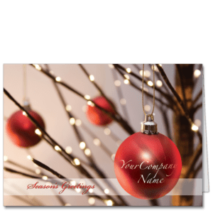 Executive holiday cards with red ornament featuring company name and twigs with glowy lights in background