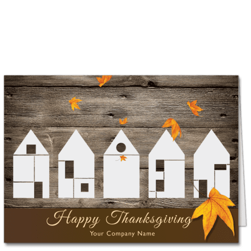 Company Thanksgiving cards with a contemporary design. Five Type 5 construction style houses all in a row against a rich, warm brown wood barn style background. A few bright orange autumn leaves are falling and your company name is featured on the card front at the bottom.